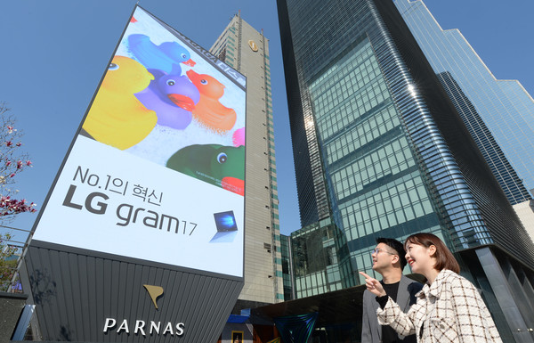 모델들이 서울 강남구 삼성동에 위치한 파르나스 호텔 앞에서 LG전자가 설치한 고화질의 초대형 LG LED 사이니지를 소개하고 있다. 사진/LG전자