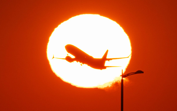 인천국제공항 활주로에 떠오르는 태양 위로 여객기가 힘차게 날아오르고 있다. ⓒ연합뉴스